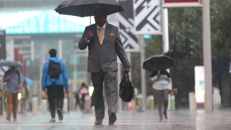 People walk along Wembley Way, north west London in the rain,, as the Met Office has issued a yellow warning for thunderstorms and heavy rain in south and eastern England, with driving conditions potentially affected by spray, standing water and even hail, as well as possible delays to train services, power cuts, flooding and lightning strikes. Picture date: Thursday August 25, 2022.

