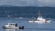 A US coastguard boat and sheriff boat search the area near Freeland, Washington state on Whidbey Island north of Seattle where a chartered floatplane crashed. Pic: AP/Stephen Brashear)