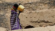 A woman from the Turkana pastoralist community affected by the worsening drought due to failed rain seasons, drinks water from an open well dug on a dry riverbed in Kakimat village in Turkana, Kenya September 27, 2022
