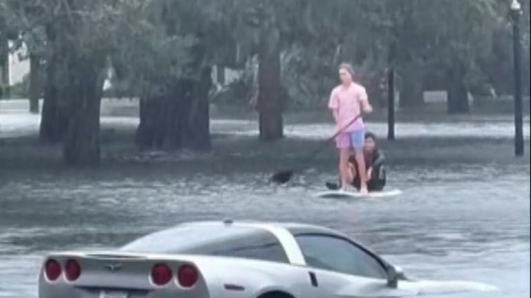 People paddle board through floodwaters in Orlando