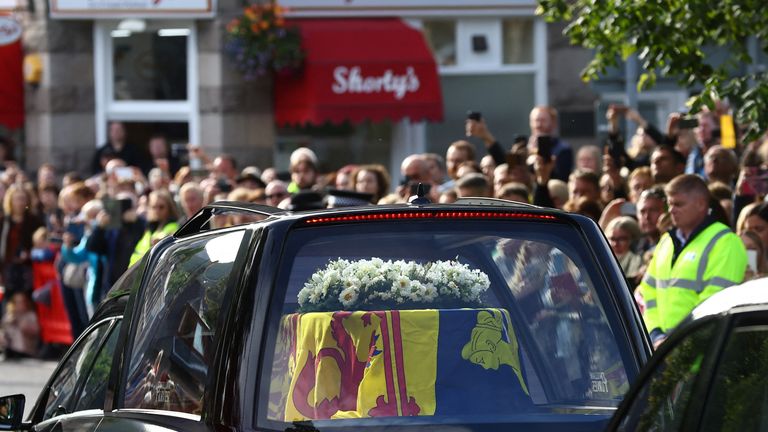 People line the street as the hearse carrying the coffin of Britain&#39;s Queen Elizabeth passes through the village of Ballater, near Balmoral, Scotland, Britain, September 11, 2022. REUTERS/Hannah McKay