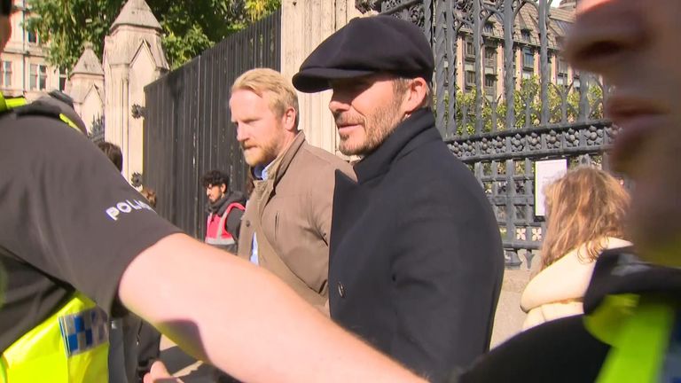 The former English football captain was seen by Sky News wearing a dark flat cap, suit and tie as he waited to pay his respects.