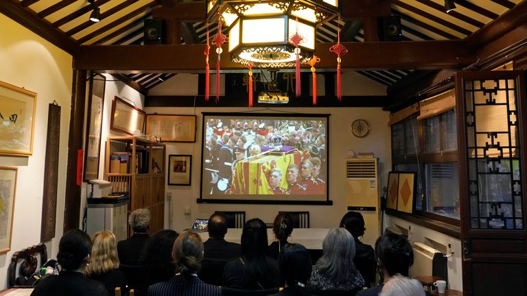 Foreign and Chinese residents gather at a private live viewing of Queen Elizabeth II&#39;s funeral on a screen in Beijing, Monday, Sept. 19, 2022. (AP Photo/Ng Han Guan)
