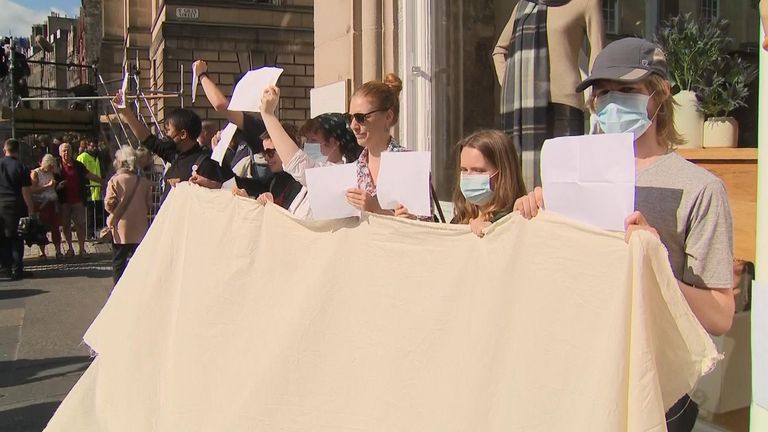 Group protests against breach of the peace arrests by holding up blank paper - while being heckled by monarchists.