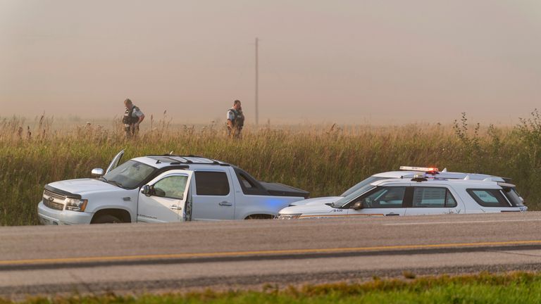 Police and investigators gather at the scene where a stabbing suspect was arrested in Rosthern, Saskatchewan on Wednesday, Sept. 7, 2022. Canadian police arrested Myles Sanderson, the second suspect in the stabbing deaths of multiple people in Saskatchewan, after a three-day manhunt that also yielded the body of his brother fellow suspect, Damien Sanderson.(Heywood Yu/The Canadian Press via AP)