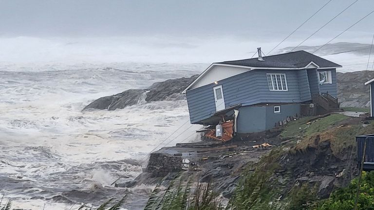 Waves roll past a damaged house built near the shore as Hurricane Fiona, later downgraded to a post-tropical cyclone, passes the Atlantic settlement of Port aux Basques, Newfoundland and Labrador, Canada on September 24 2022. Courtesy of Wreckhouse Press/Handout via REUTERS NO RESALE.  NO ARCHIVES.  THIS IMAGE WAS PROVIDED BY A THIRD PARTY.  COMPULSORY CREDIT