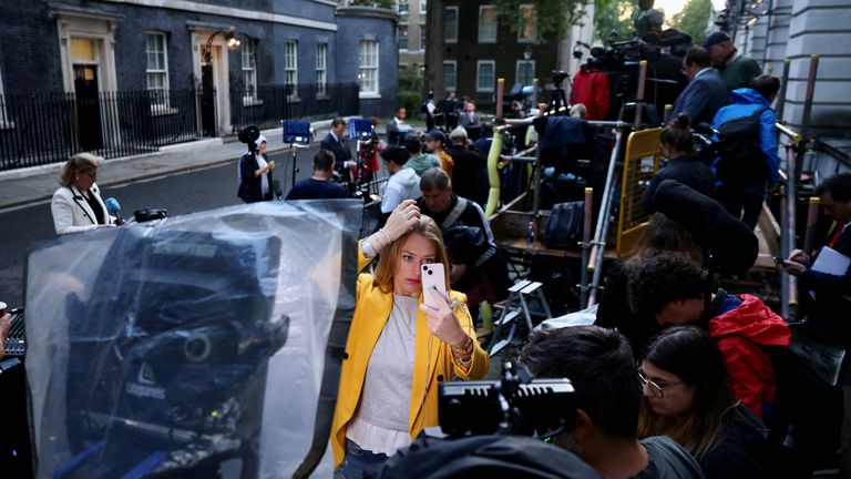 A television journalist adjusts her hair before a broadcast in Downing Street, London, Britain September 6, 2022. REUTERS/Kevin Coombs