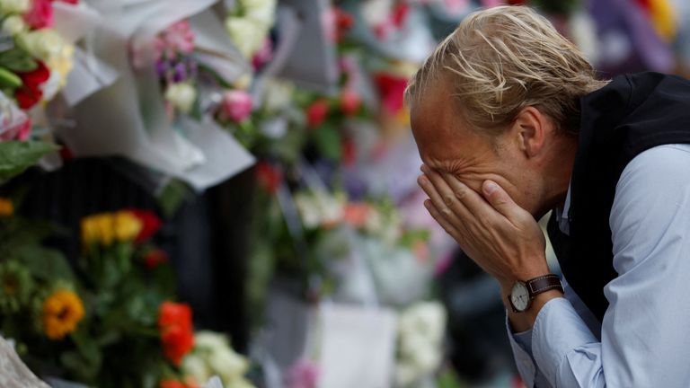 A man reacts near floral tributes placed at Buckingham Palace, following the passing of Queen Elizabeth, in London, Britain, September 9, 2022. REUTERS/John Sibley
