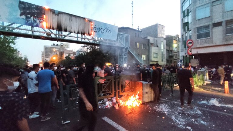 People light a fire during a protest over the death of Mahsa Amini, a woman who died after being arrested by the Islamic republic&#39;s "morality police", in Tehran, Iran September 21, 2022. WANA (West Asia News Agency) via REUTERS ATTENTION EDITORS - THIS IMAGE HAS BEEN SUPPLIED BY A THIRD PARTY. BEST QUALITY AVAILABLE DUE TO LIGHTING CONDITIONS
