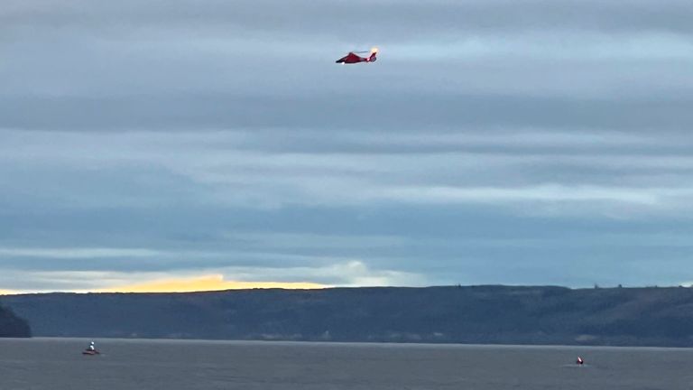 A US Coast Guard helicopter patrols the area where a seaplane crashed near Whidbey Island, Washington state.  Pic: Courtney Riffkin / The Seattle Times via AP