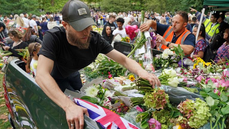 Staff from the Royal household distribute flowers to the public in Green Park, near Buckingham Palace, London. Queen Elizabeth II&#39;s coffin is travelling from Balmoral to Edinburgh, where it will lie at rest at the Palace of Holyroodhouse. Picture date: Sunday September 11, 2022.

