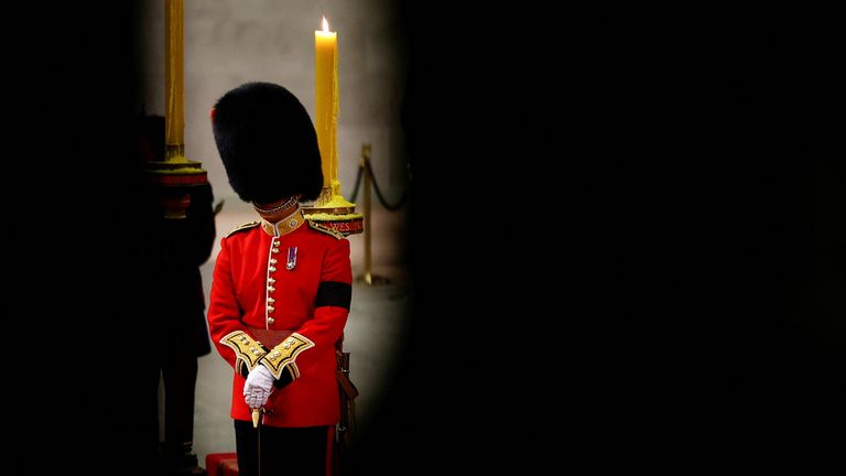 A royal guard stands beside the coffin of Queen Elizabeth II, draped in the Royal Standard with the Imperial State Crown and the Sovereign&#39;s orb and sceptre, lying in state on the catafalque in Westminster Hall, at the Palace of Westminster, London. Picture date: Sunday September 18, 2022.