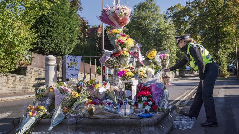 A police officer lays a floral tribute at the scene in Woodhouse Hill, Huddersfield, where 15-year-old schoolboy Khayri McLean was fatally stabbed outside his school gates.  Photo date: Friday, September 23, 2022.