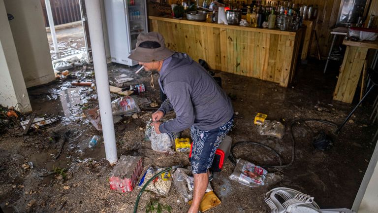 A man removes damaged food from a restaurant affected during the passing of Hurricane Fiona in Penuelas, Puerto Rico