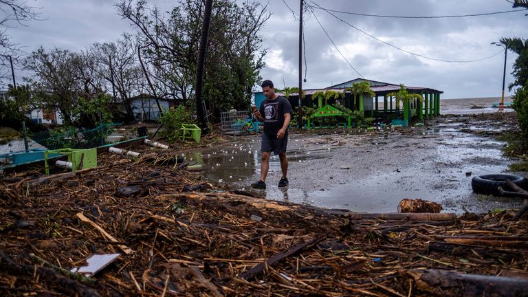 A man walks through debris in the aftermath of Hurricane Fiona in Guayanilla, Puerto Rico 