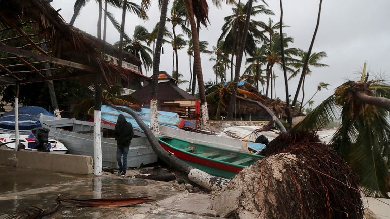 A person walks amidst debris on the seashore in the aftermath of Hurricane Fiona in Punta Cana, Dominican Republic, September 19, 2022. REUTERS/Ricardo Rojas
