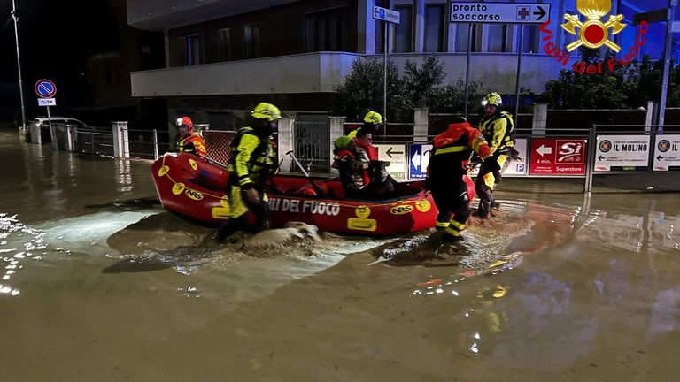 Rescue workers using a dinghy to evacuate residents in the town of Senigallia