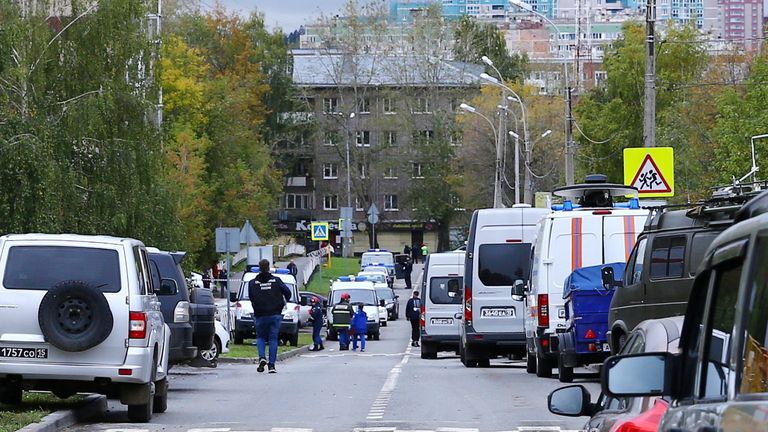 A woman talks to police officers securing area after a school shooting in Izhevsk, Russia September 26, 2022. REUTERS/Stringer
