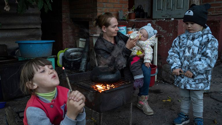 FILE - Margaryta Tkachenko feeds her 9-month-old daughter Sophia in the recently liberated town of Izium, Ukraine, on Sept. 25, 2022. Hundreds of children from eastern Ukraine are stranded in Russian summer camps, on the wrong side of a frontline that shifted after they were bused away for what was supposed to be holiday. Tkachenko, was among those who refused an offer she said sounded too good to be true. She rejected the Russian soldiers who came to her roofless home to press the issue. (AP Photo/Evgeniy Maloletka, File)