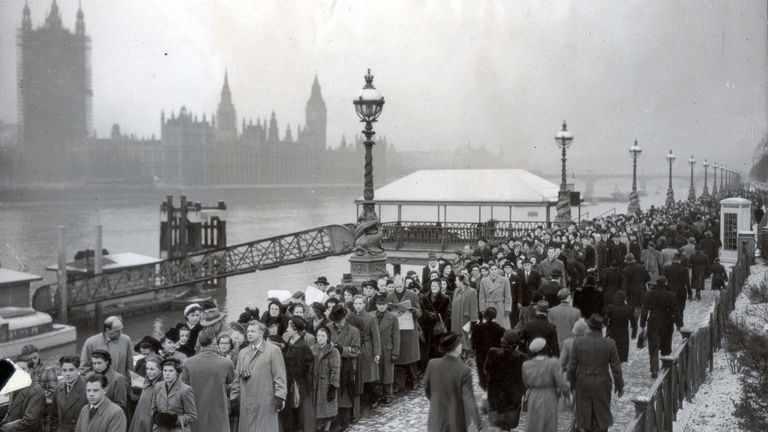 DEATH OF KING GEORGE VI (DIED 6/2/52) LYING IN STATE, LONDON SCENES, FEBRUARY 1952.Queue for lying-in-state spans river this morning..This picture, taken just before 8.30 this morning (Wednesday) shows the queue for the lying-in-state of King George VI extending along the south bank of the Thames by St Thomas&#39;s Hospital as far as the eye can see..Despite the snow on the ground and on rooftops, and the bitter cold, people wishing to pay tribute to the King stood in a gigantic line stretching back from Westminster hall - the Houses of Parliament buildings are seen in the background, on the other side of the river - and over Lambeth Bridge..February 13th 1952...ROYALTY