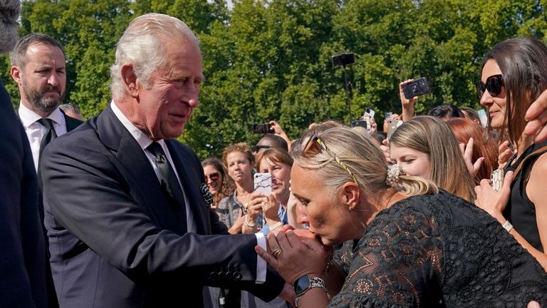 A well-wisher kisses the hand of King Charles III during a walkabout outside Buckingham Palace, London, to view messages and tributes following the death of Queen Elizabeth II on Thursday. Picture date: Friday September 9, 2022.
