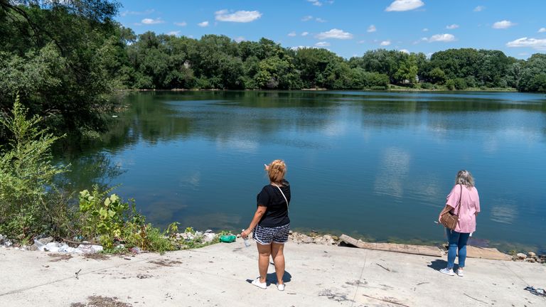 Searchers look at a large pond, Tuesday, July 12, 2022, during a hunt for Kyle Moorman, who went missing with his three children a week ago. This area, near Bluff Road and West Troy Avenue is a spot Moorman liked to go fishing. The bodies of a man and three young children were found in an Indianapolis pond amid a search for a father and his kids who had been missing since last week, authorities said Wednesday. (Robert Scheer/The Indianapolis Star via AP)