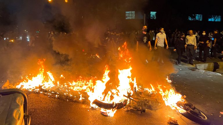 A police motorcycle burns during a protest over the death of Mahsa Amini, a woman who died after being arrested by the Islamic republic&#39;s "morality police", in Tehran, Iran September 19