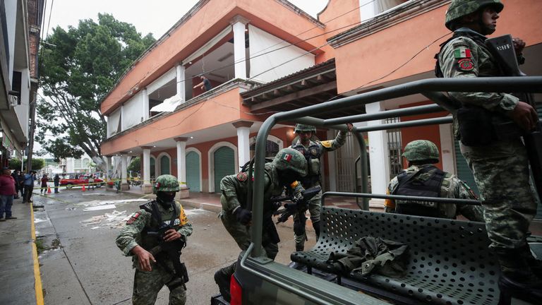 Security forces get on a vehicle near a damaged mall after an earthquake on Monday, in Coalcoman, Michoacan, Mexico. Pic: Reuters 
