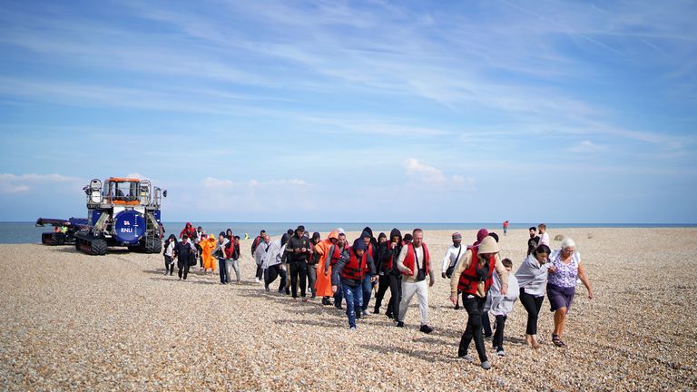 A group of people thought to be migrants walk ashore in Dungeness, Kent, after being intercepted by the Dungeness Lifeboat following a small boat incident in the Channel. Picture date: Saturday September 3, 2022.

