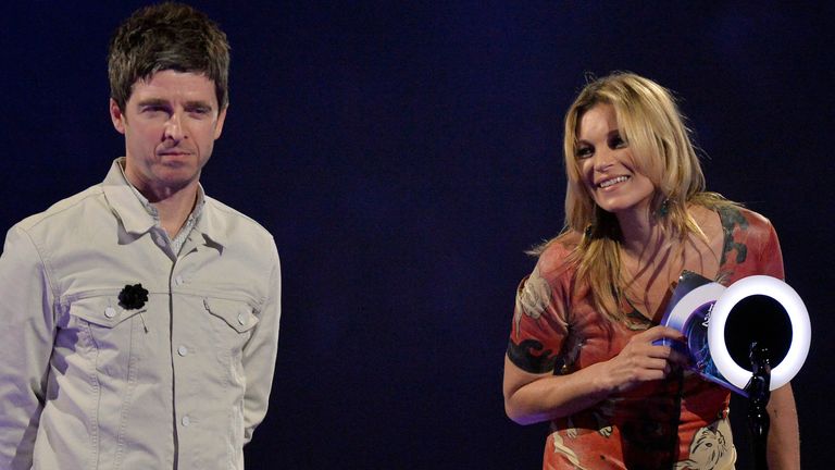 La modelo Kate Moss acepta el premio British Male Solo Artist en nombre de David Bowie mientras el músico Noel Gallagher observa los premios BRIT 2014.