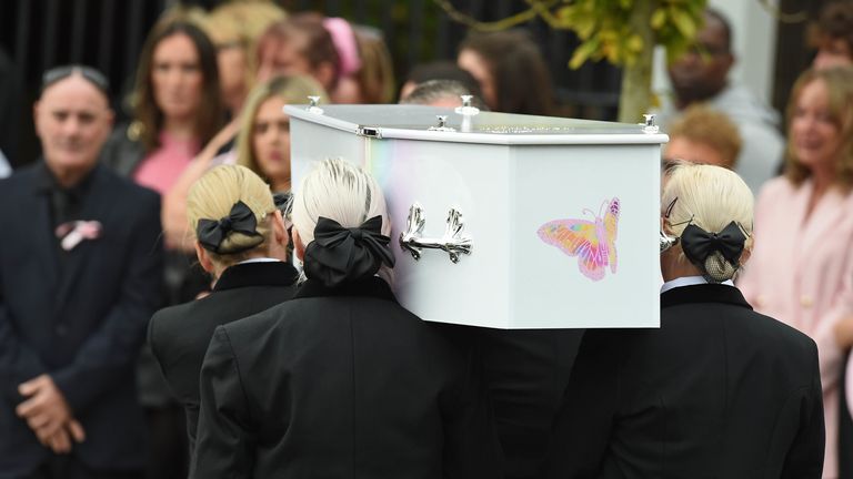 Pallbearers carry the coffin into the church