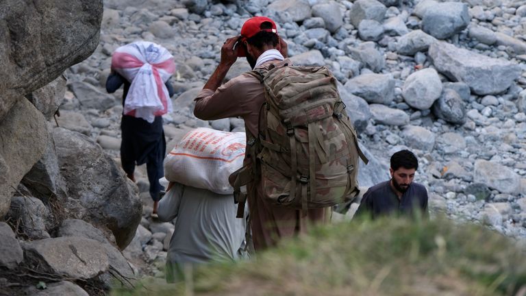 Local resident Khalid carries a backpack of supplies