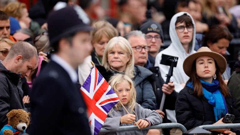 Police officers, teddy bears, and flag-waving children are all gathered in Parliament Square