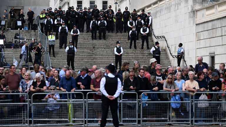 Police officers stand guard as people wait ahead of the procession of the coffin of Britain&#39;s Queen Elizabeth, in London, Britain, September 14, 2022. REUTERS/Clodagh Kilcoyne
