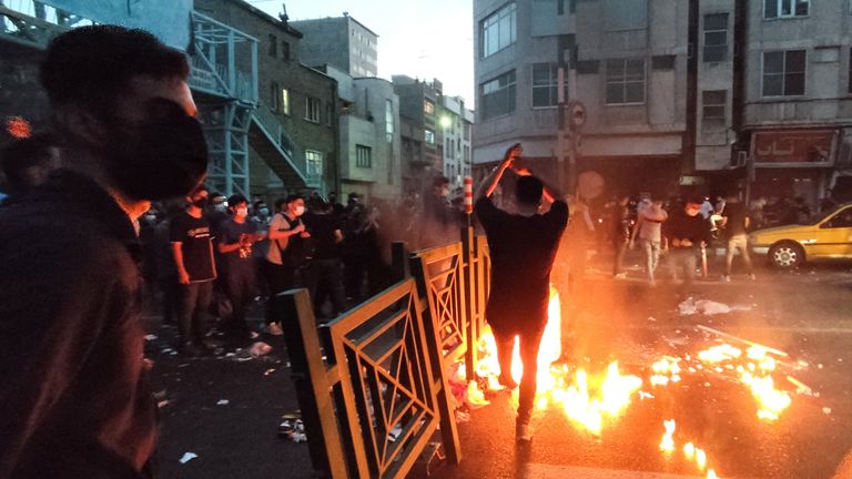 People light a fire during a protest over the death of Mahsa Amini, a woman who died after being arrested by the Islamic republic&#39;s "morality police", in Tehran, Iran September 21, 2022. WANA (West Asia News Agency) via REUTERS ATTENTION EDITORS - THIS IMAGE HAS BEEN SUPPLIED BY A THIRD PARTY. BEST QUALITY AVAILABLE DUE TO LIGHTING CONDITIONS
