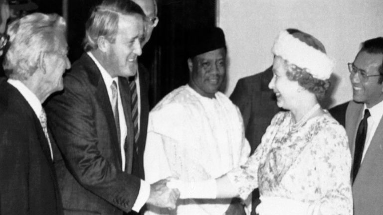 La reina Isabel II de Gran Bretaña le da la mano al primer ministro canadiense, Brian Mulroney.  El primer ministro australiano, Bob Hawke, observa, a la izquierda, junto con el presidente de Nigeria, Ibrahim Babangida, y el primer ministro de Singapur, Goh Chok Tong, en el extremo derecho.  La ocasión fue una reunión del Grupo de Evaluación de Alto Nivel en Harare, Zimbabue, el 15 de octubre de 1991. (Foto AP/Sayyid Azim)
