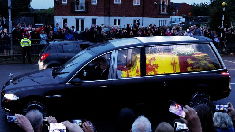 People watch a hearse carrying the coffin of Britain's Queen Elizabeth after her death, after leaving RAF Northolt, in London, Britain September 13, 2022. REUTERS / Andrew Couldridge