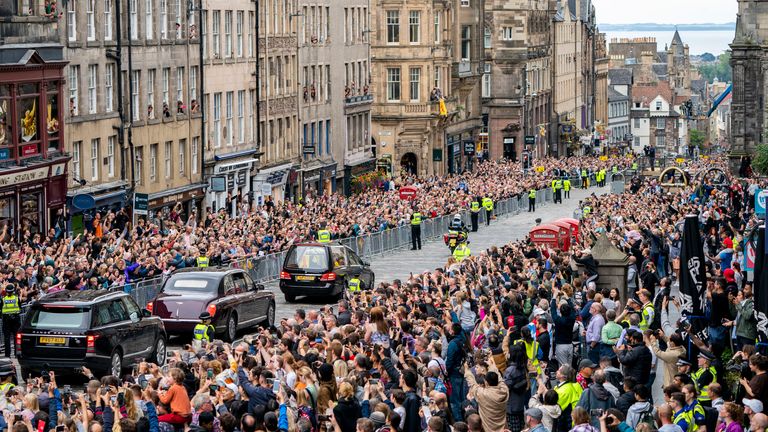 The hearse carrying the coffin of Queen Elizabeth II, draped with the Royal Standard of Scotland, passes on the Royal Mile, Edinburgh, Sunday, Sept. 11, 2022 on the journey from Balmoral to the Palace of Holyroodhouse in Edinburgh, where it will lie in rest for a day. (Jane Barlow/Pool Photo via AP)