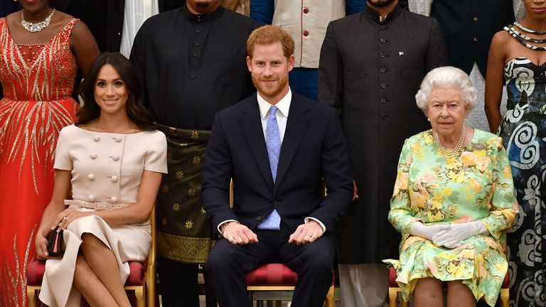 FILE PHOTO: Britain&#39;s Queen Elizabeth, Prince Harry and Meghan, the Duchess of Sussex pose for a picture with some of Queen&#39;s Young Leaders at a Buckingham Palace reception following the final Queen&#39;s Young Leaders Awards Ceremony, in London, Britain June 26, 2018. John Stillwell/Pool via Reuters/File Photo
