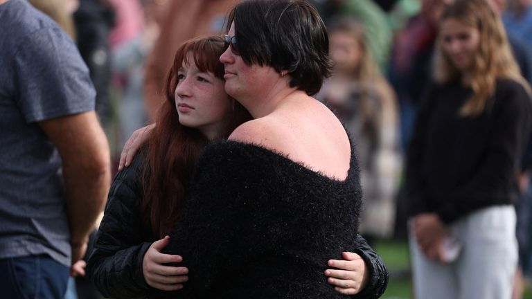 Mourners embrace at the funeral of Queen Elizabeth in Holyrood Park, Edinburgh