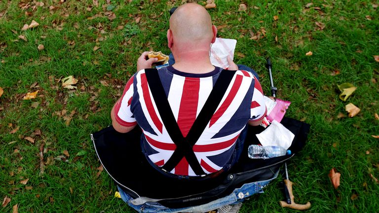 A patriotic mourner, braces and all, enjoyed a spot of lunch in Windsor ahead of the arrival of the Queen&#39;s coffin. Pic: AP