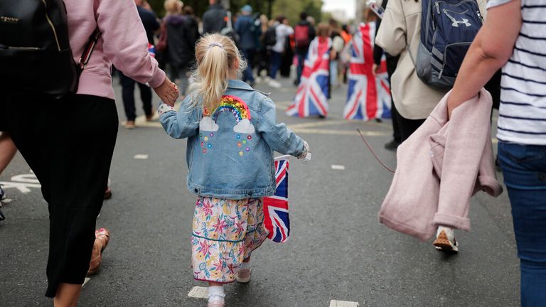 A young girl who is unlikely to have another Queen in her lifetime carries a Union Jack ahead of the historic service. Pic: AP