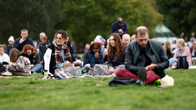 People sit on grass at Hyde Park, on the day of state funeral and burial of Britain&#39;s Queen Elizabeth, in London, Britain, September 19, 2022 REUTERS/Jason Cairnduff
