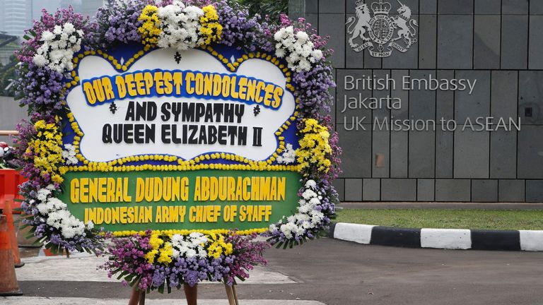A delivery man carries a wreath as he walks to a British Embassy in Jakarta, Indonesia