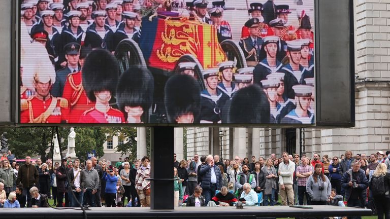 يتجمع الناس في City Hall في بلفاست ، أيرلندا الشمالية ، لمشاهدة التغطية التلفزيونية لجنازة الملكة إليزابيث الثانية ، الاثنين 19 سبتمبر 2022.  (AP Photo / Peter Morrison)