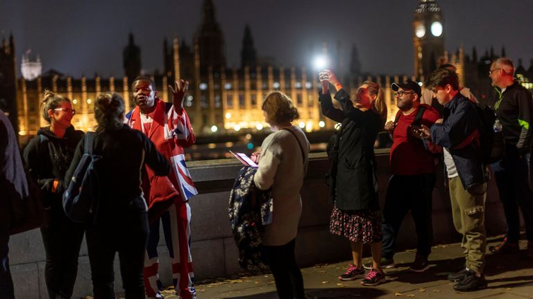 A person wearing a suit in the colours of the British flag queues to pay respects to the Queen, as the coffin of Britain&#39;s Queen Elizabeth lies in state at Westminster Hall, in London, Britain, September 14, 2022. REUTERS/Carlos Barria