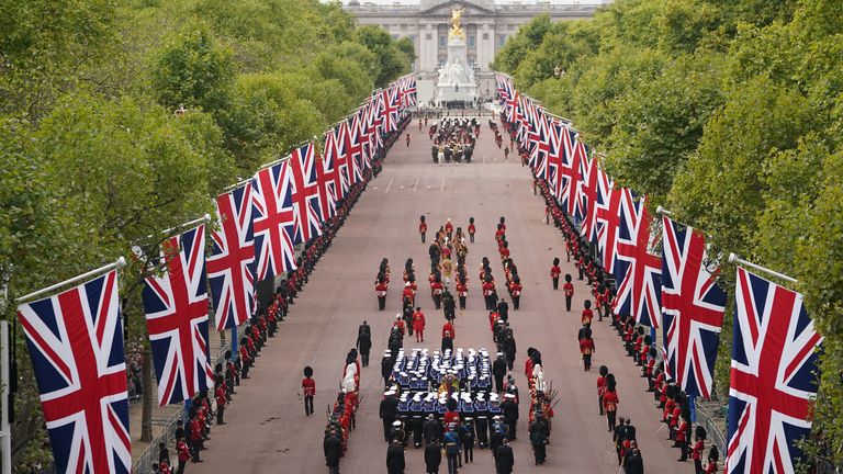 A state carriage carries the coffin of Queen Elizabeth II, draped in the Royal Standard with the Imperial State Crown and Sovereign Orb and Sceptre, in a ceremonial procession following her state funeral at Westminster Abbey in London.  Photo date: Monday, September 19, 2022.