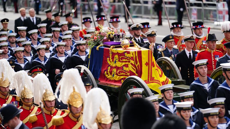 State gun carriage carries the coffin of Queen Elizabeth II in drapery in Royal Standard with Imperial state crown and orb and scepter of the Sovereign, in Ceremonial procession following her state funeral at Westminster Abbey in London.  Photo date: Monday, September 19, 2022