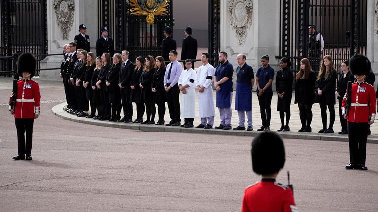 Buckingham Palace staff stand outside its gates during Queen Elizabeth II funeral ceremonies in central London Monday, Sept. 19, 2022. The Queen, who died aged 96 on Sept. 8, will be buried at Windsor alongside her late husband, Prince Philip, who died last year. Christophe Ena/Pool via REUTERS