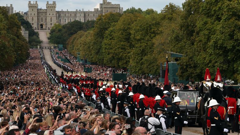 A hearse carrying the coffin of Britain's Queen Elizabeth is escorted along the Long Road towards Windsor Castle during the funeral, on the day of the national mourning and burial of Queen Elizabeth, in Windsor, England, September 19, 2022 REUTERS / Paul Childs